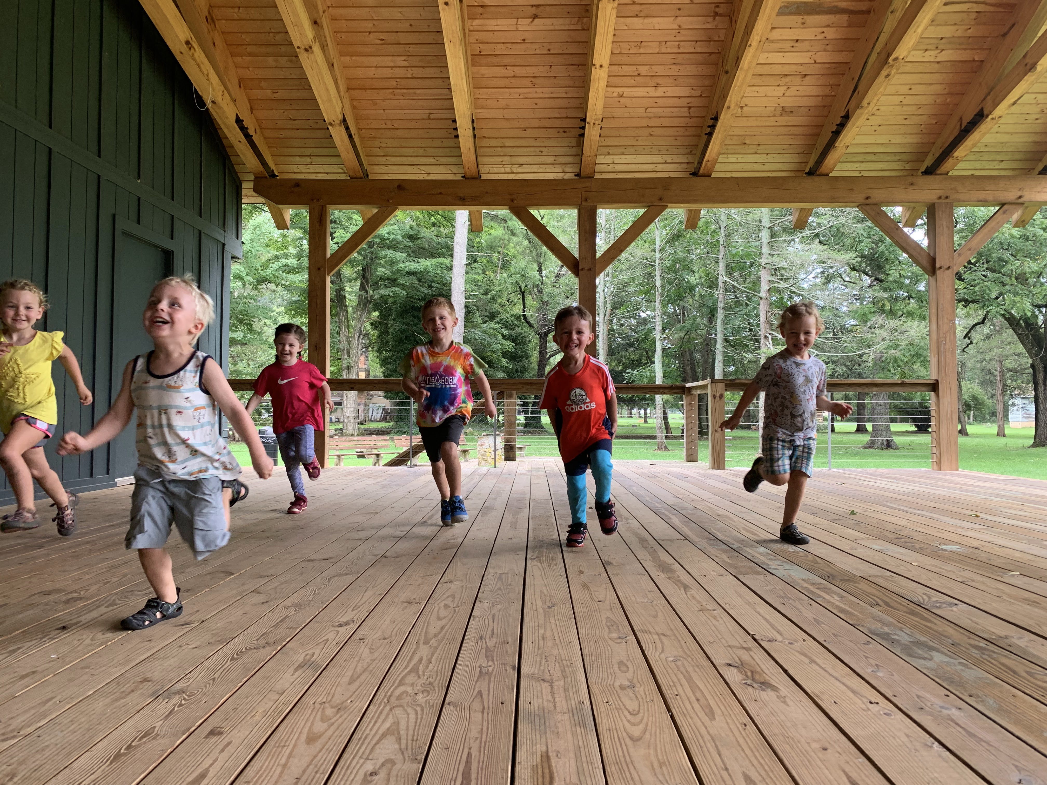 preschoolers running under a covered outdoor structure